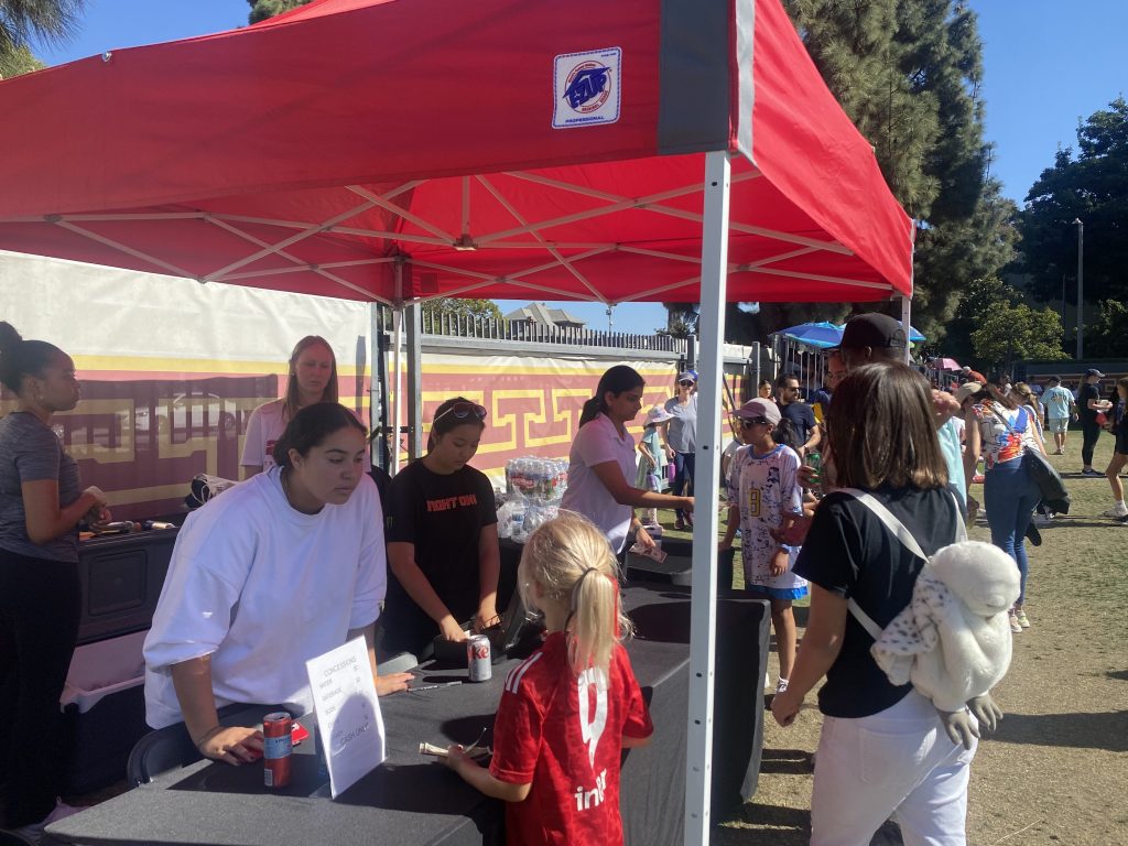 Fans at the concessions stand under a tent on the north side of Soni McAlister Field.