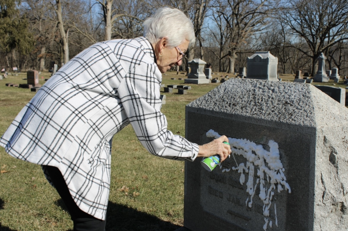 Martin spraying shaving cream on a headstone.